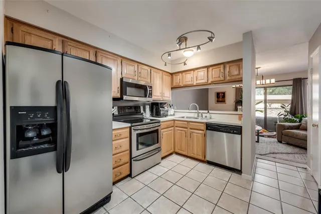 a kitchen with stainless steel appliances granite countertop a refrigerator sink and stove