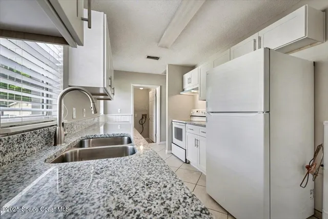 a kitchen with granite countertop cabinets stainless steel appliances a sink and a window