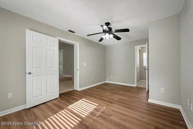 a view of empty room with wooden floor and window