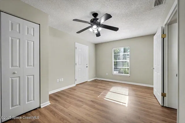 a bathroom with a granite countertop toilet a sink and a window