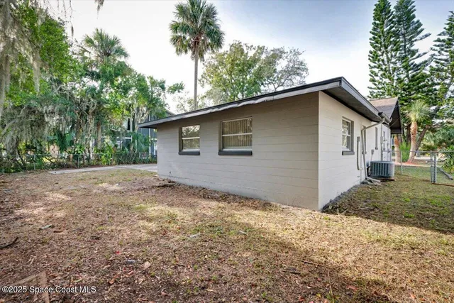 a backyard of a house with large trees and garage