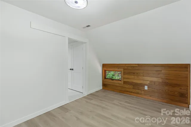 an empty room with windows and fireplace