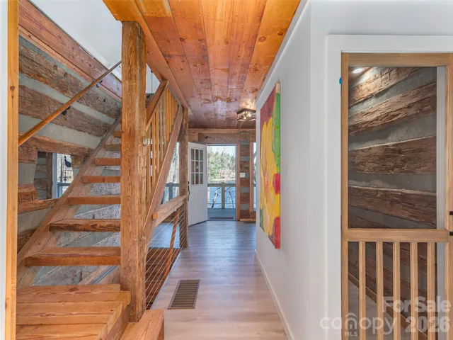 a view of a hallway with wooden floor and staircase
