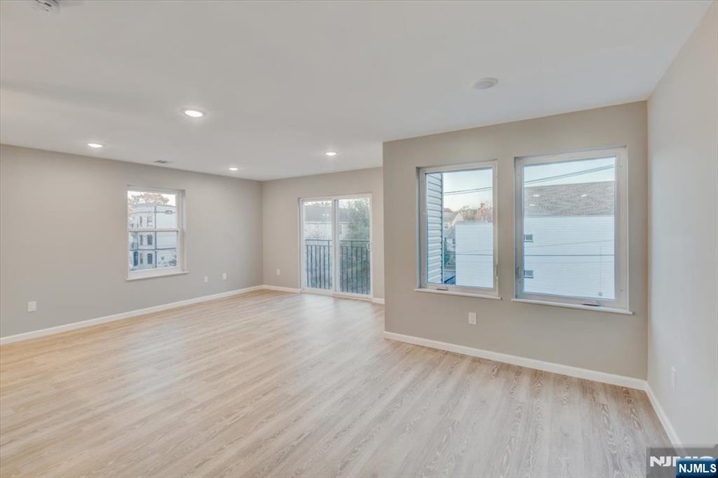 581 Bergen Street Newark, NJ 07108 - Photo 11 of 30 an empty room with wooden floor and windows