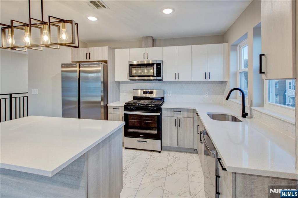 581 Bergen Street Newark, NJ 07108 - Photo 17 of 30 a kitchen with stainless steel appliances a refrigerator sink and cabinets