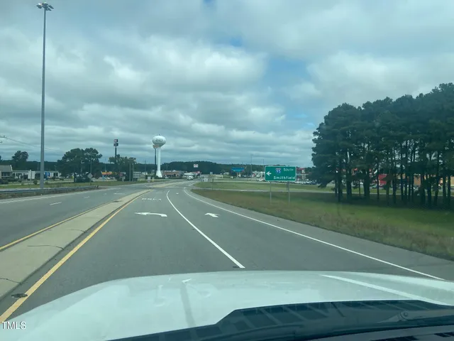 a view of a water with a big yard and a large trees
