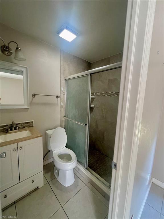 1756 52nd Terrace Southwest Naples, FL 34116 - Photo 12 of 18 a bathroom with a granite countertop toilet a sink and a shower