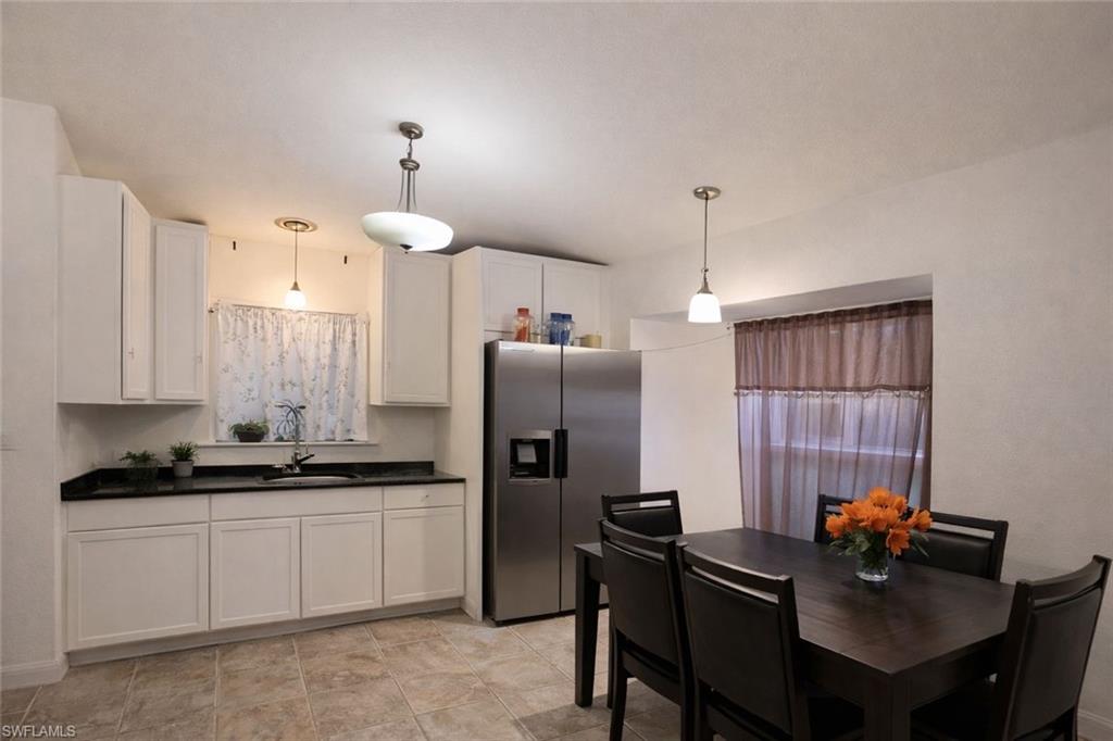 2275 Robin Drive Naples, FL 34117 - Photo 5 of 15 Kitchen featuring white cabinetry, stainless steel fridge with ice dispenser, and pendant lighting