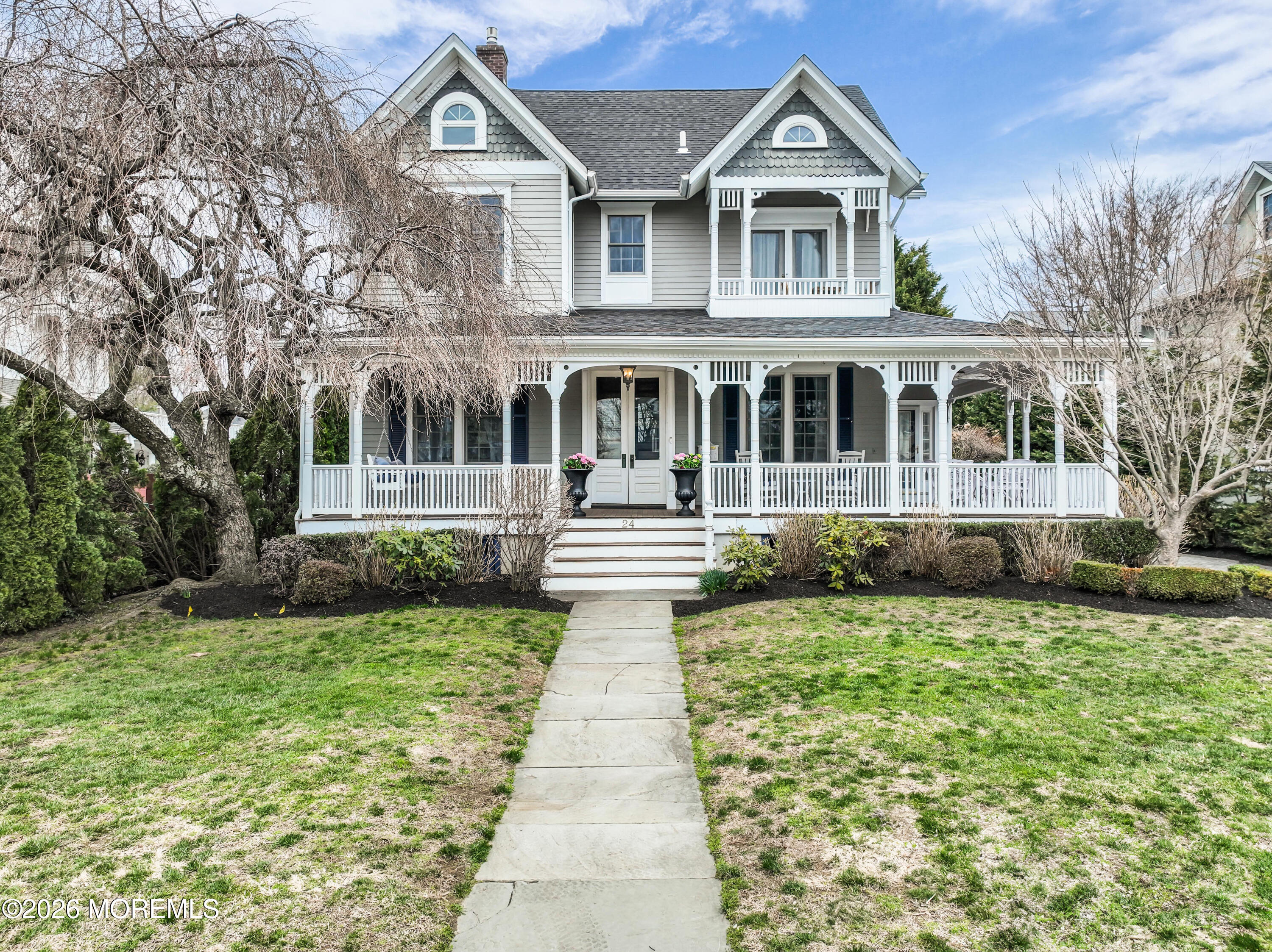 a front view of a house with a garden and trees