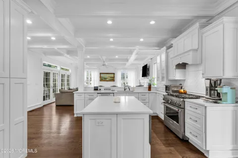 a large white kitchen with lots of counter space a sink appliances and cabinets