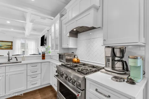 a kitchen with cabinets appliances and wooden floor