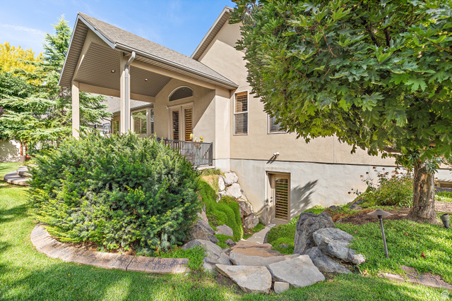 552 East Johns Way Sandy, UT 84070 - Photo 61 of 67 Covered patio with recessed lighting, stone paver pathway, mature trees, and established landscaping