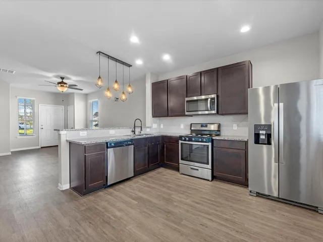 a large kitchen with stainless steel appliances and a refrigerator