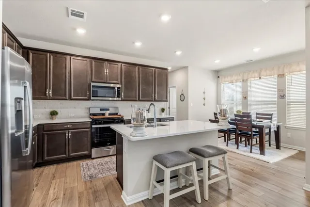 a kitchen with microwave a stove top oven and cabinets