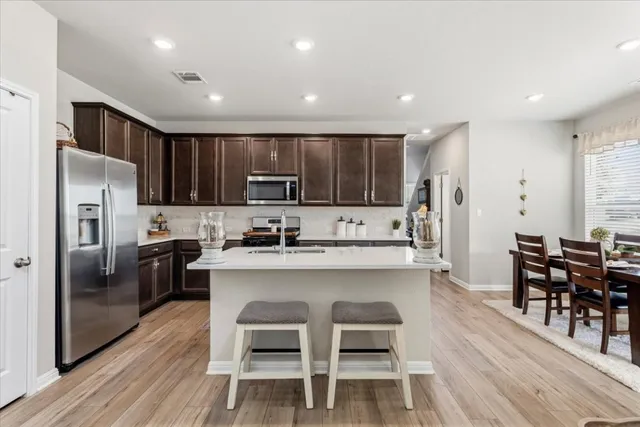 a kitchen with kitchen island wooden cabinets and stainless steel appliances