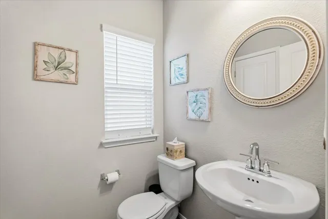 a bathroom with a toilet a sink and a mirror