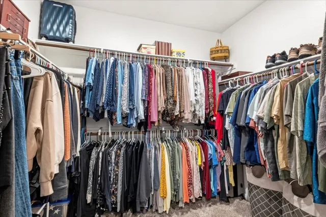 a view of walk in closet with clothes