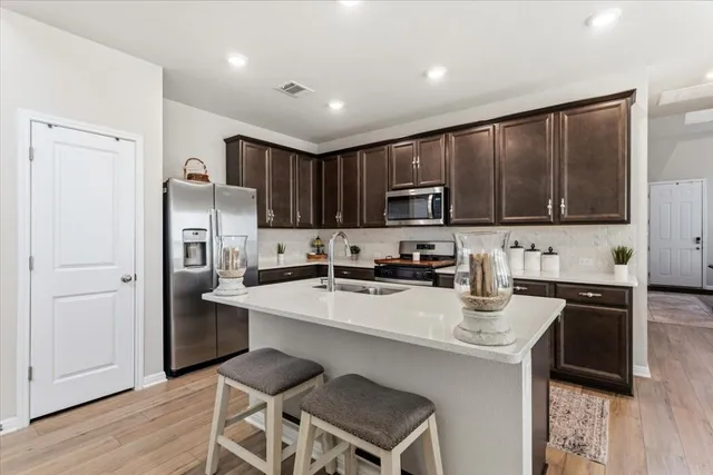 a kitchen with a refrigerator a stove a sink and cabinets