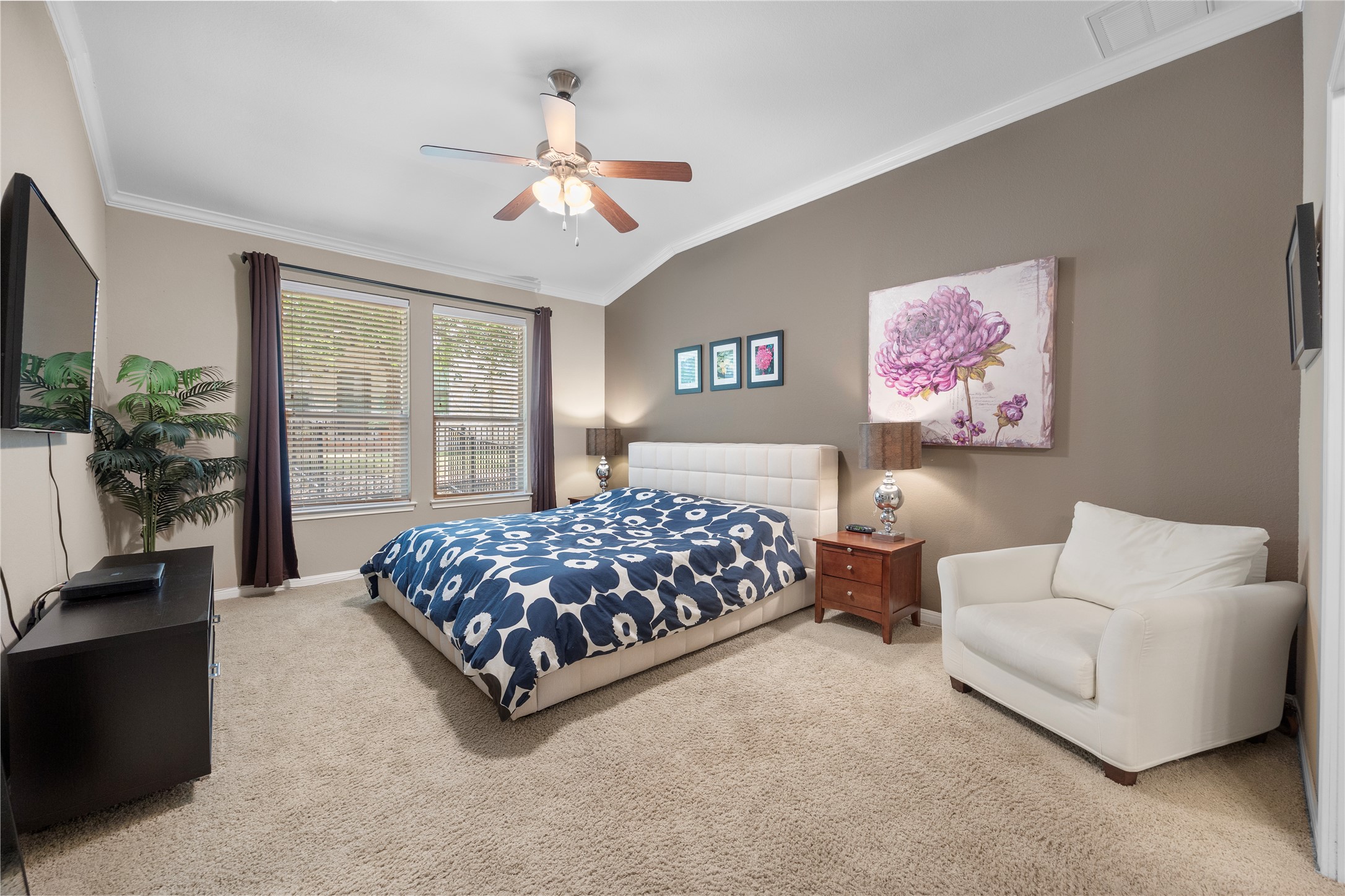 7308 Bandera Ranch Trail, Unit A Austin, TX 78750 - Photo 11 of 27 This bedroom features neutral-toned carpet, a vaulted ceiling with a fan, and two windows providing natural light