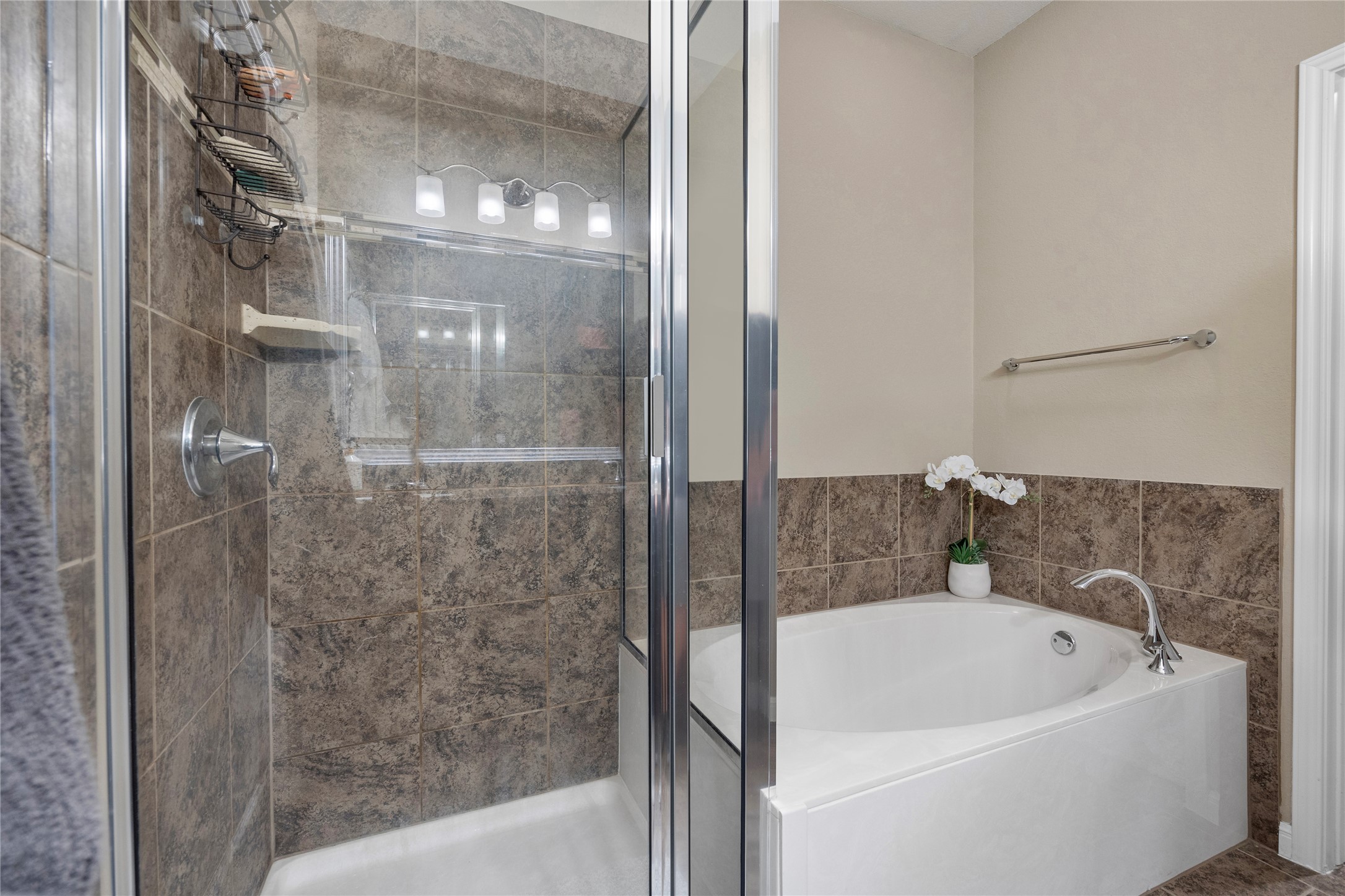 7308 Bandera Ranch Trail, Unit A Austin, TX 78750 - Photo 14 of 27 The bathroom features a corner soaking tub with a tiled surround, a glass-enclosed shower with tiled walls, and a chrome shower fixture