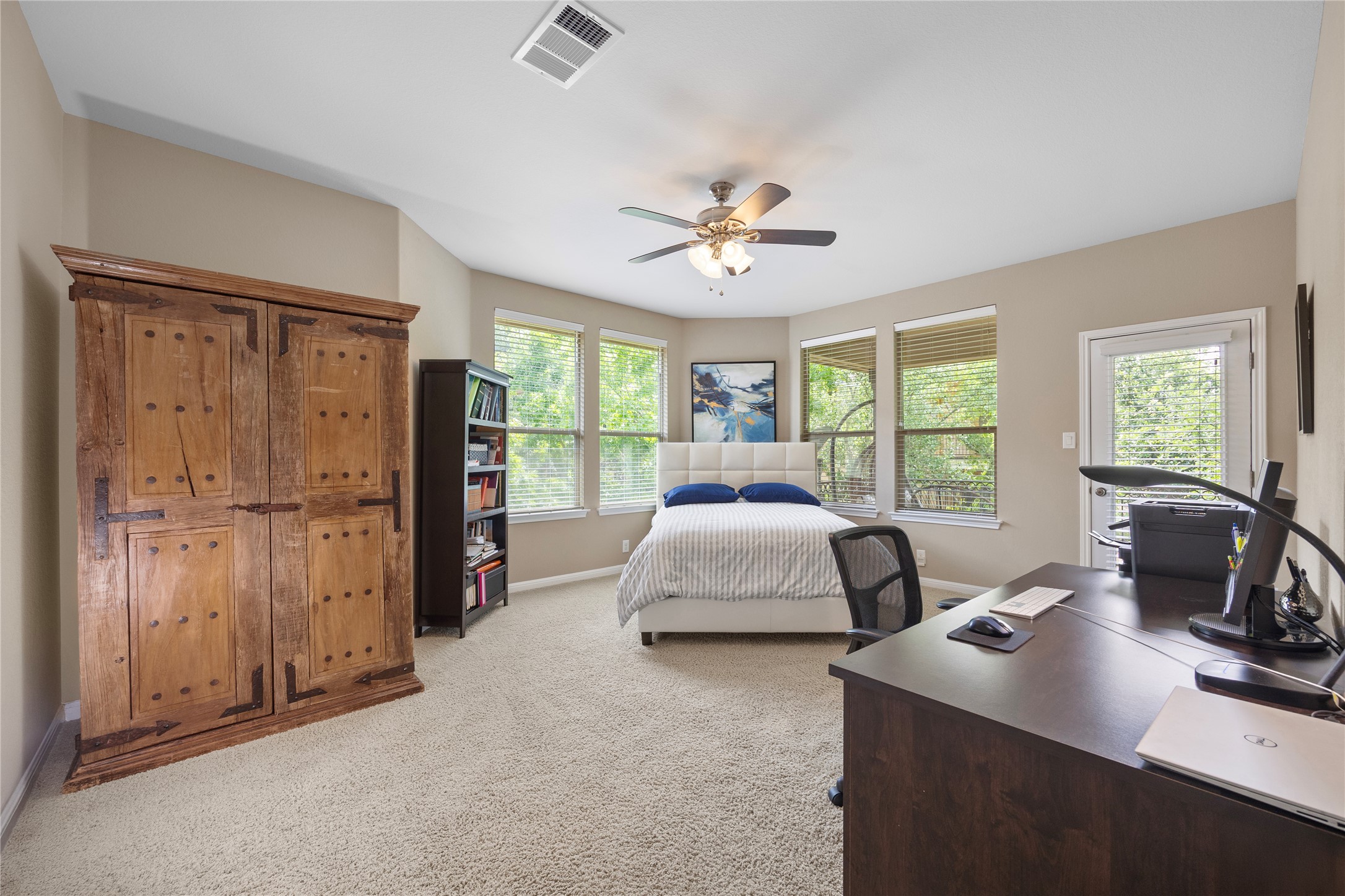 7308 Bandera Ranch Trail, Unit A Austin, TX 78750 - Photo 23 of 27 This room features light-colored carpet flooring, a ceiling fan, and several windows providing natural light