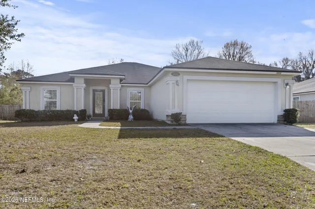 a front view of a house with a yard and a garage