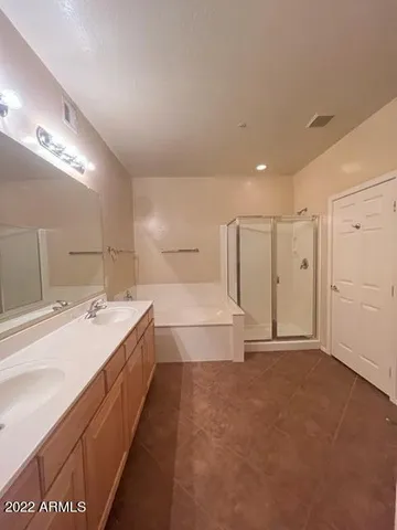 a spacious bathroom with a tub sink and a mirror
