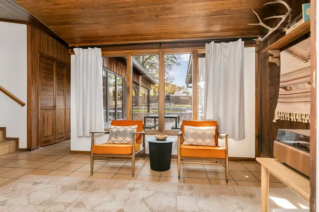 a living room with furniture a fireplace and a chandelier