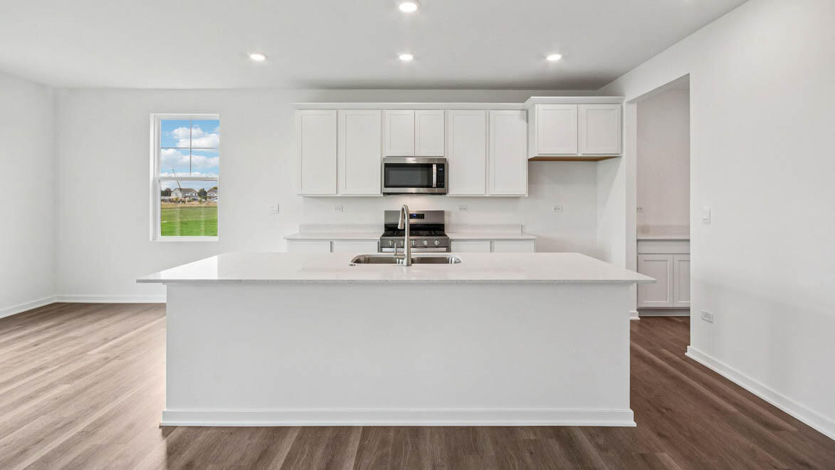 7694 West 107th Place Crown Point, IN 46307 - Photo 16 of 37 a kitchen with stainless steel appliances a stove a sink a refrigerator and a microwave