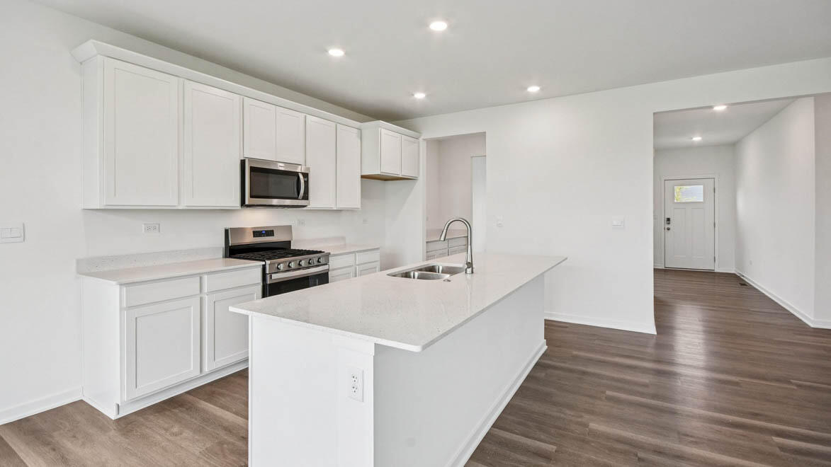 7694 West 107th Place Crown Point, IN 46307 - Photo 17 of 37 a kitchen with stainless steel appliances a stove top oven a sink a refrigerator white cabinets and wooden floor