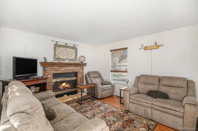 a living room with furniture a flat screen tv and a fireplace