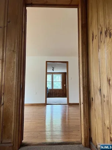 a view of a hallway with wooden floor and a window