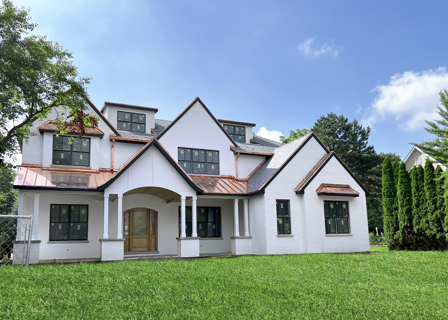 a front view of a house with a yard and trees