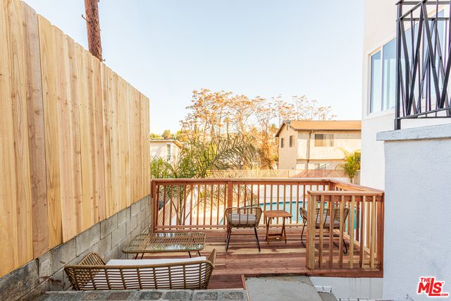 a view of a white house with a sink and potted plants