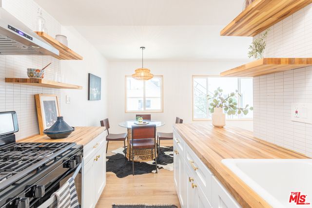 a kitchen with a stove and a wooden floor