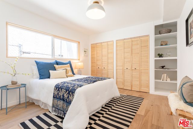 a bedroom with a bed and wooden floor