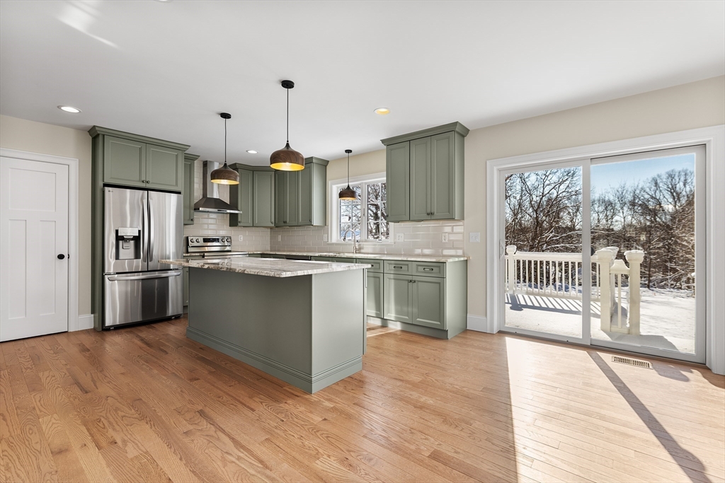 41 Lantern Lane Braintree, MA 02184 - Photo 6 of 36 a kitchen with kitchen island granite countertop a stove a sink a refrigerator and a wooden floor