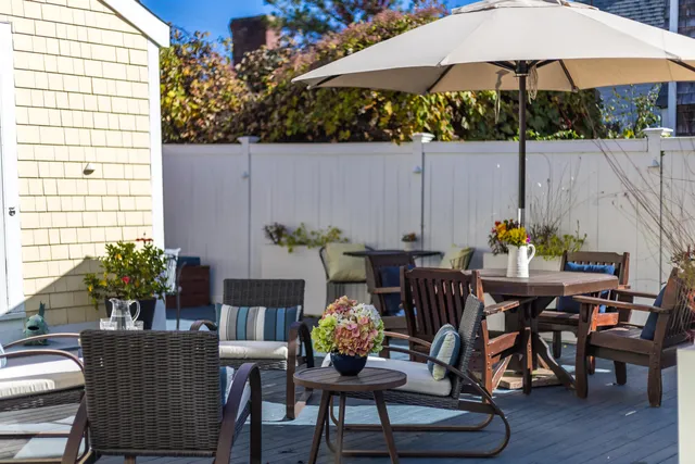 a view of a patio with a dining table and chairs under an umbrella