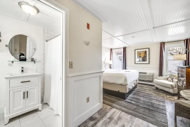 a bed sitting in a bedroom next to a window