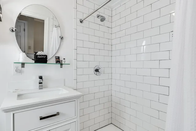 a bathroom with a sink vanity toilet and shower