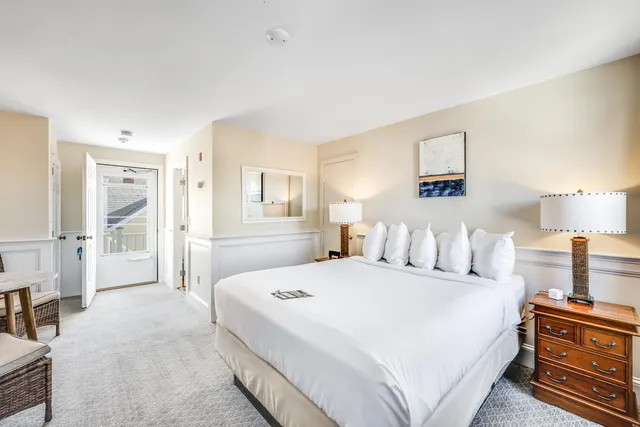 a bedroom with a bed and a lamp on dresser