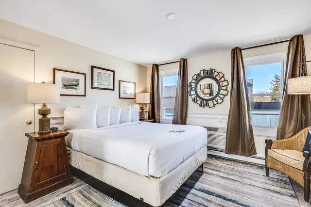 a bedroom with a large bed and a flat tv screen on dresser