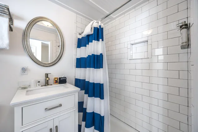 a bathroom with a sink a toilet a vanity and shower