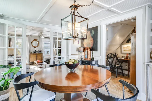 a dining room with furniture a chandelier and wooden floor