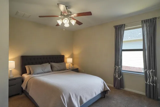 an empty room with a chandelier fan and closet area