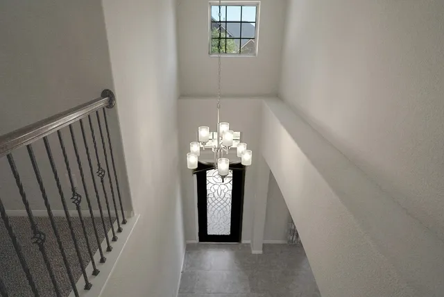 a view of a hallway with windows and chandelier