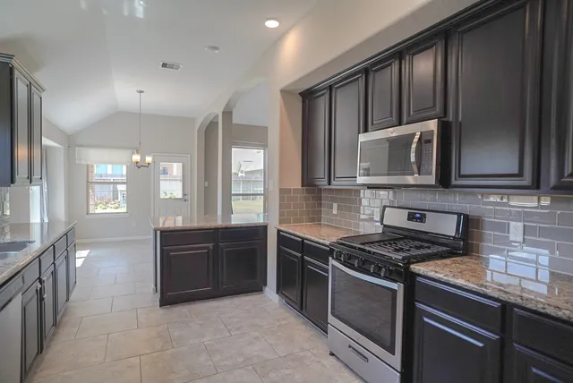 a kitchen with stainless steel appliances granite countertop a sink stove and refrigerator