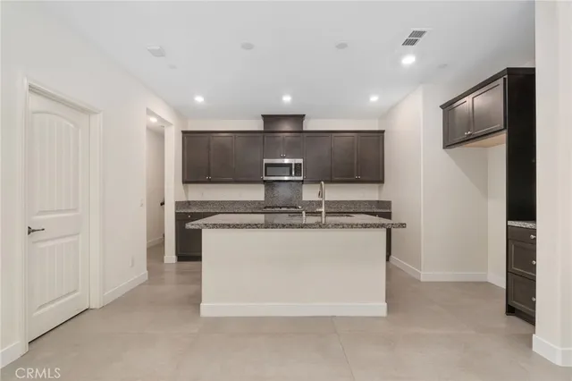 a kitchen with stainless steel appliances granite countertop a sink and a refrigerator