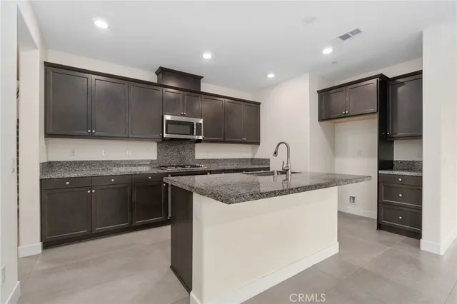 a kitchen with stainless steel appliances granite countertop a sink and a stove