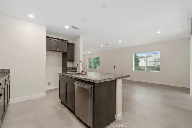 an open kitchen with a sink and a stove top oven